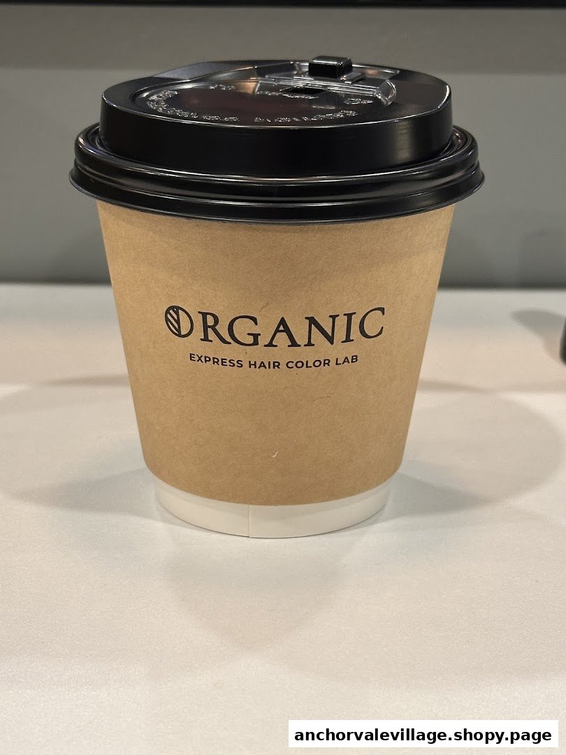 A branded coffee cup from Organic Express Hair Color Lab on a clean white surface.