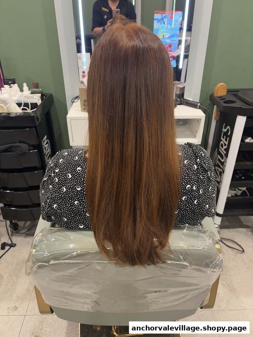 A client with long, reddish-brown hair seated in a salon chair at Organic Express Hair Color Lab.