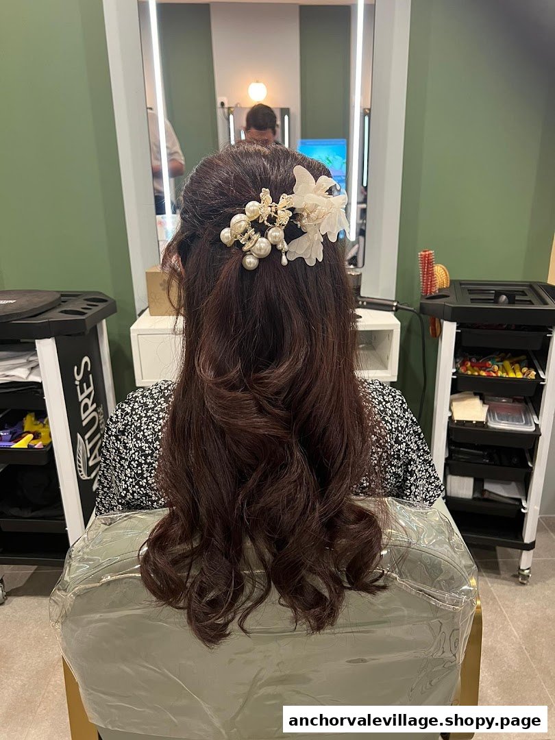 A person with elegantly styled hair adorned with a floral and pearl accessory, seen from behind in a salon.