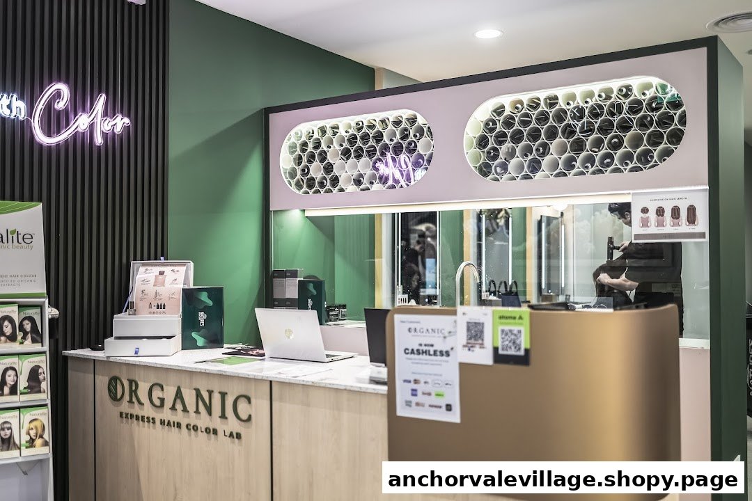 An interior shot of Organic Express Hair Color Lab, featuring a modern reception counter, product displays, and a neon sign.