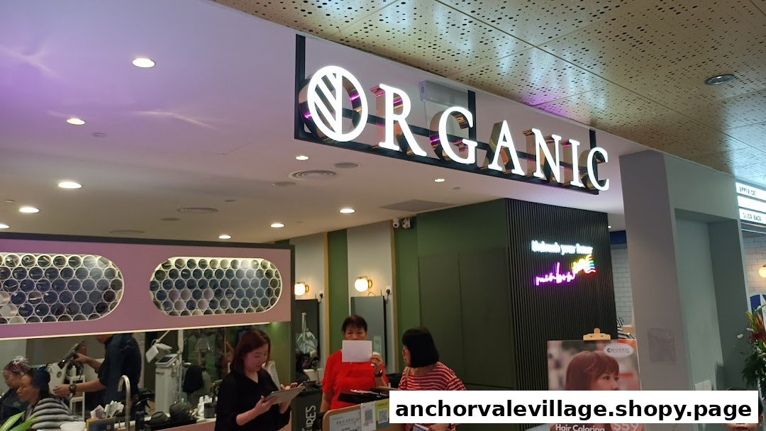 The image captures the brightly lit entrance of 'Organic Express Hair Color Lab' with its prominent signage and a view of the bustling interior.