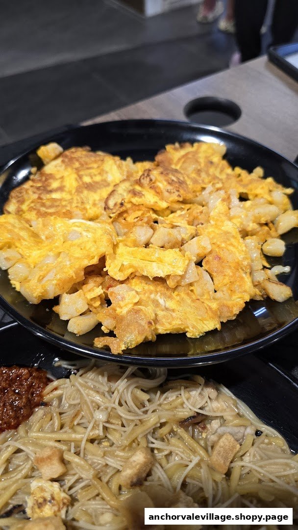 Close-up of delicious fried carrot cake and noodles with chili from Original Simon Road Hokkien Mee.