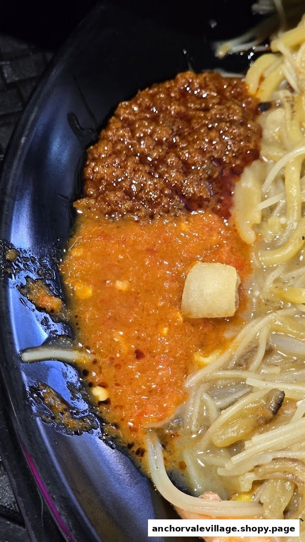 Close-up of Hokkien Mee with two types of chili sauce and crispy pork lard.