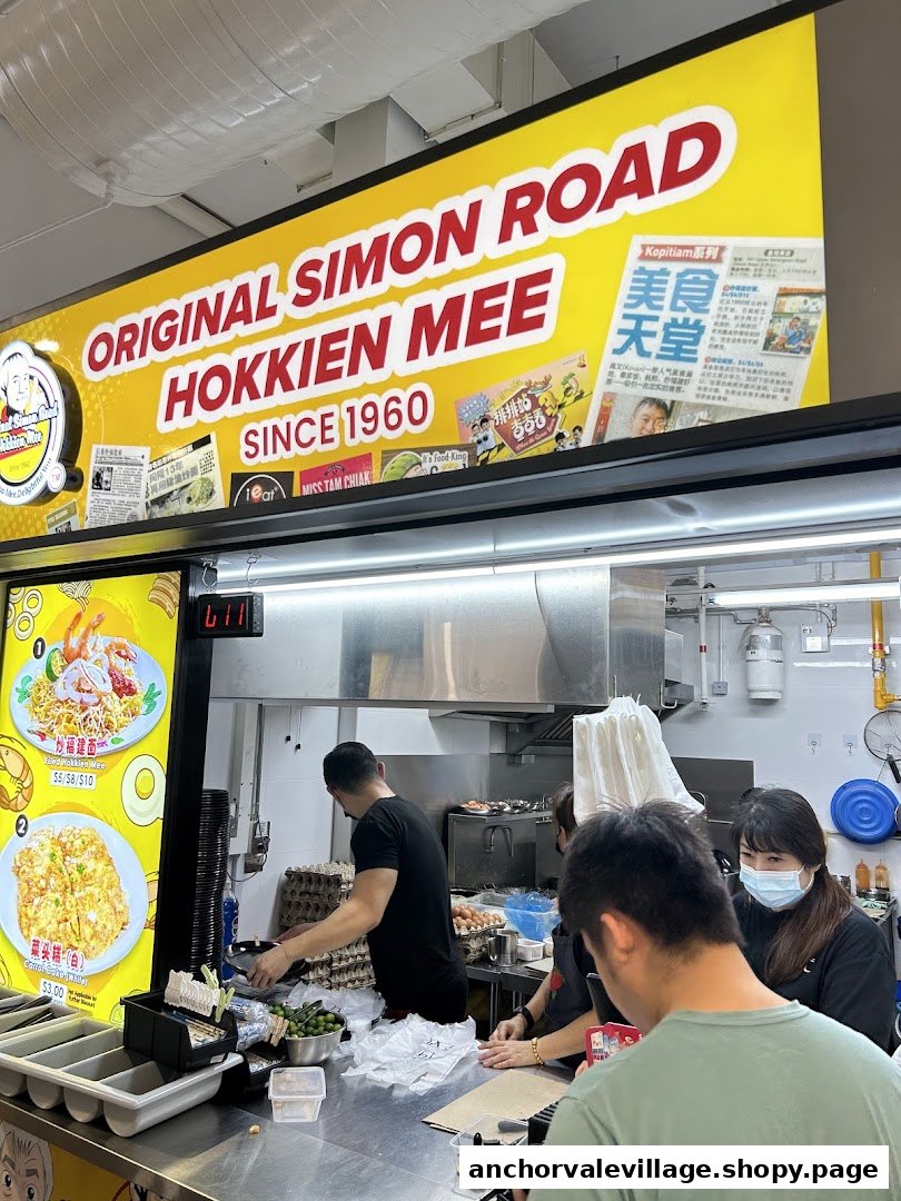 Staff prepare dishes at Original Simon Road Hokkien Mee, showcasing their cooking station and menu.