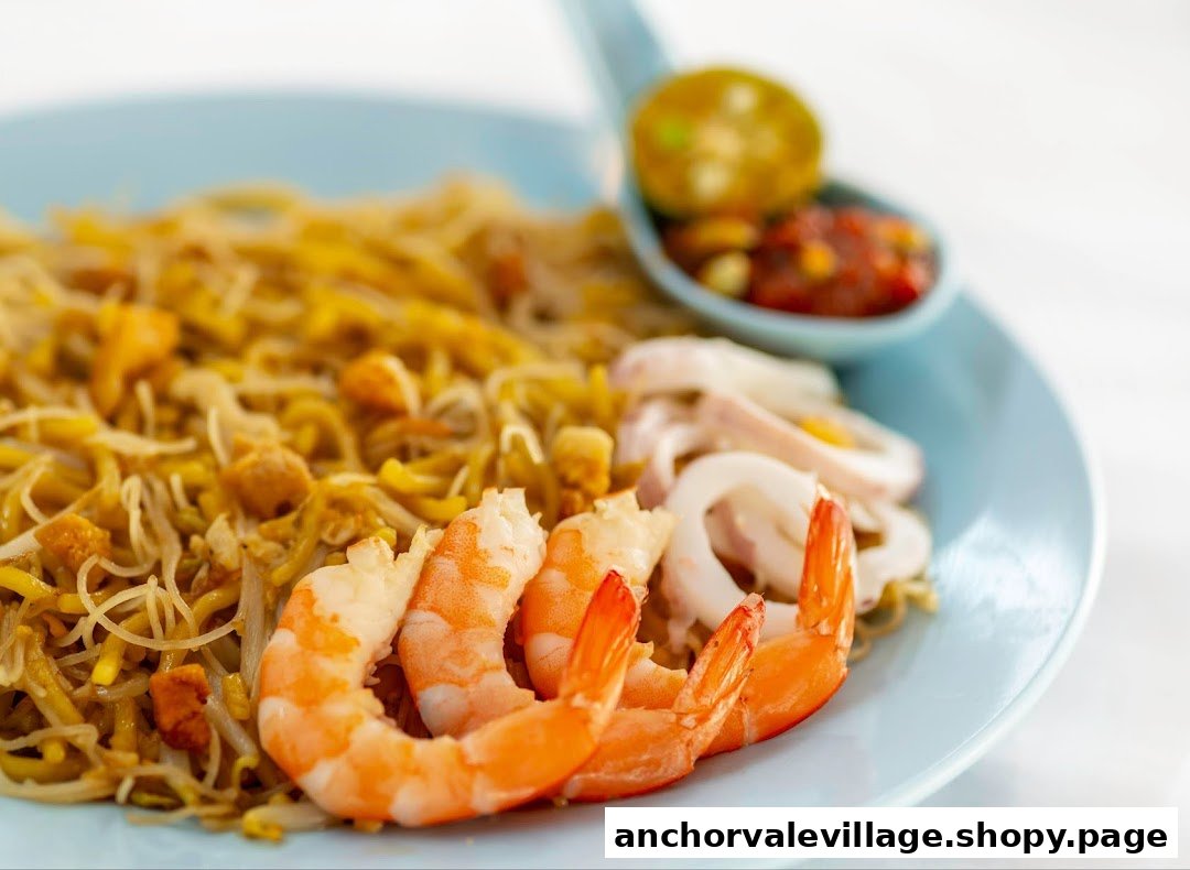 A close-up of Hokkien Mee with prawns, squid, and a side of sambal chili.