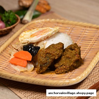 A delicious plate of rice, rendang-style meat, fried egg, and vegetables on a woven tray.