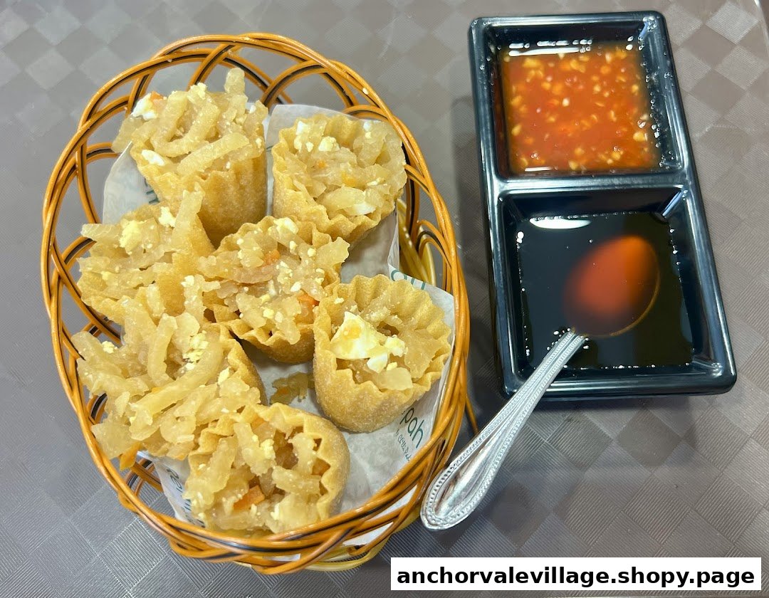 A basket of golden-brown tarts filled with savory ingredients, served with two distinct dipping sauces.