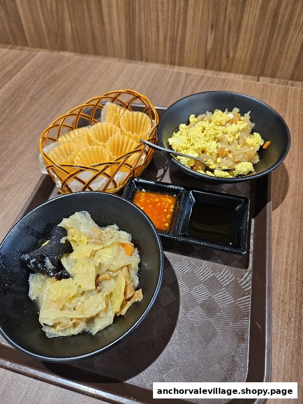 A tray with traditional Peranakan dishes including crispy cups, braised vegetables, and egg topping with sauces.