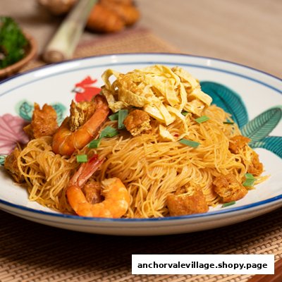 A vibrant plate of stir-fried vermicelli noodles with prawns, egg strips, and fried tofu.