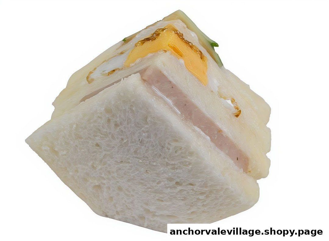 A close-up shot of a multi-layered sandwich with egg and ham fillings.