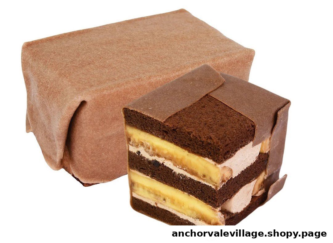 A delicious chocolate cake with banana and cream layers, partially unwrapped on a white background.