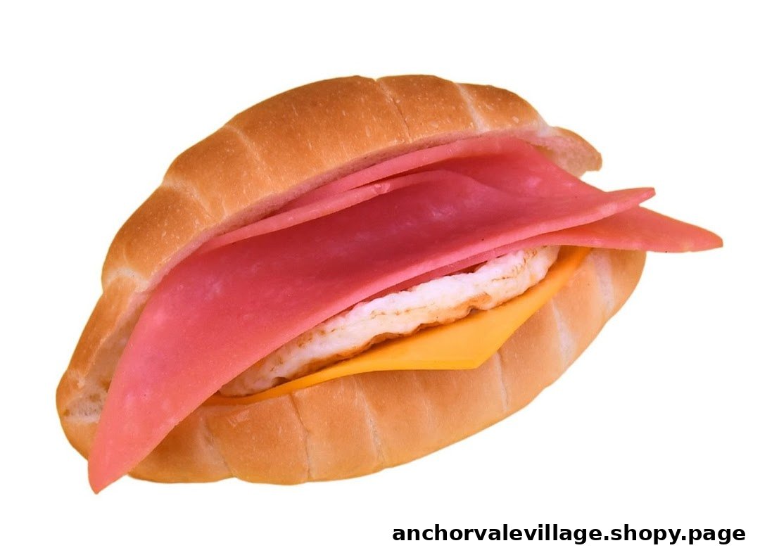 A close-up of a delicious sandwich featuring ham, cheese, and egg on a soft bun.