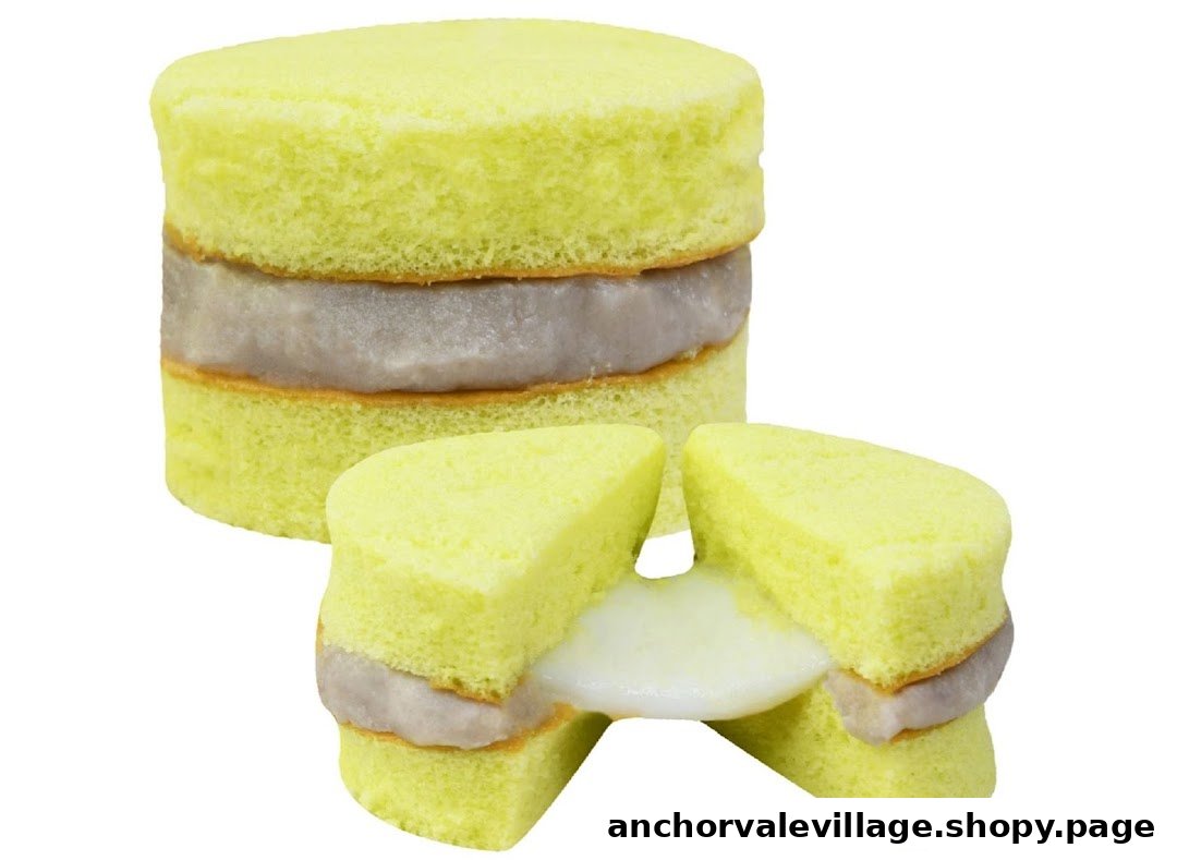 A vibrant yellow layered sponge cake with purple and white fillings, one piece pulled apart.