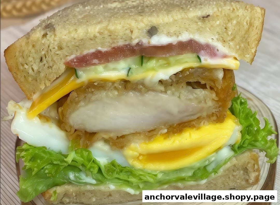 A close-up of a delicious sandwich filled with fried chicken, egg, lettuce, tomato, and sauce.