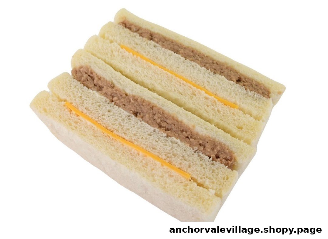 A close-up of a delicious sandwich with tuna filling and a slice of cheese.