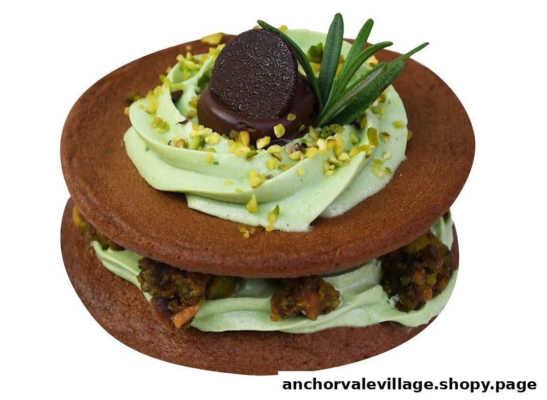 A close-up of a dessert sandwich with green cream, chocolate, and pistachio toppings.