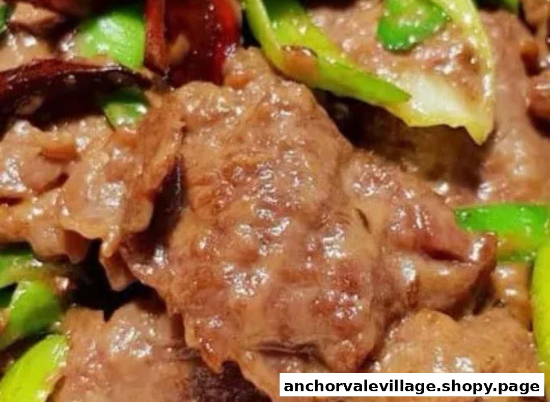 A close-up of savory stir-fried meat with green peppers and chili.