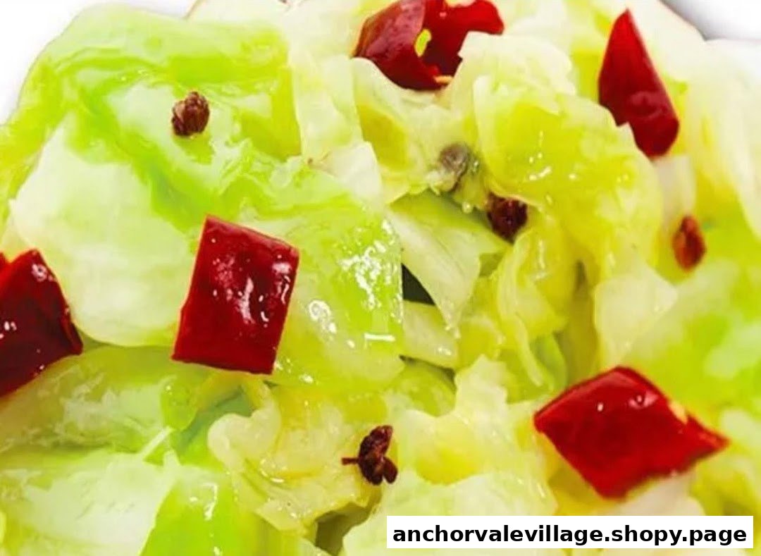 A close-up of vibrant green stir-fried cabbage with red chili pieces and dark spices.