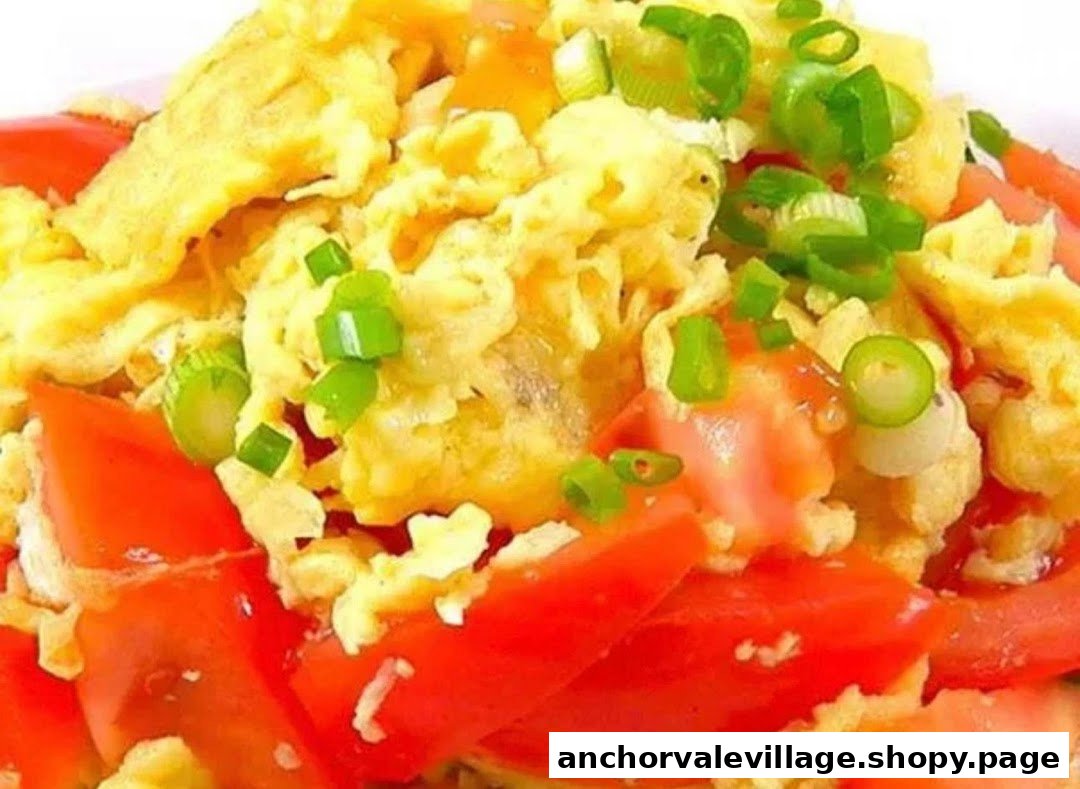 A vibrant dish featuring fluffy scrambled eggs, fresh red tomatoes, and chopped green onions.