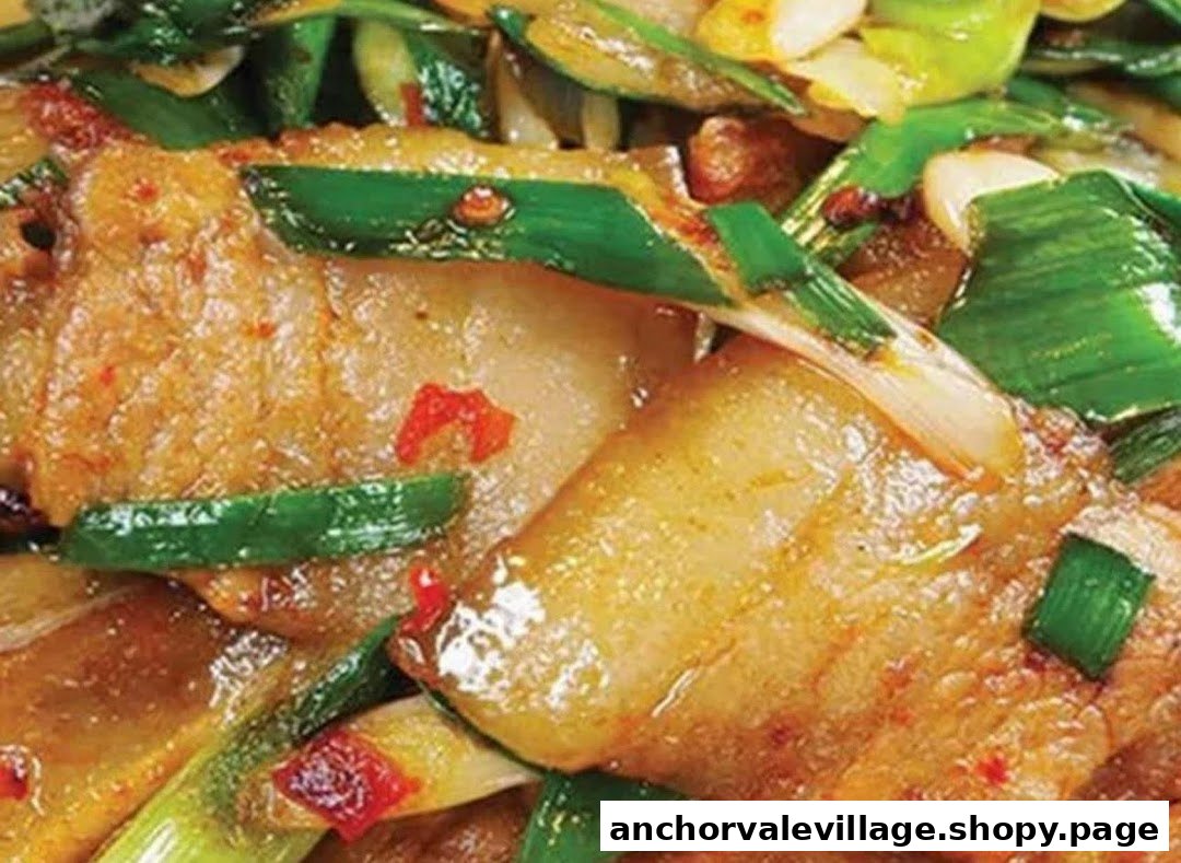 A close-up of a savory stir-fried dish featuring meat, green onions, and chili flakes.
