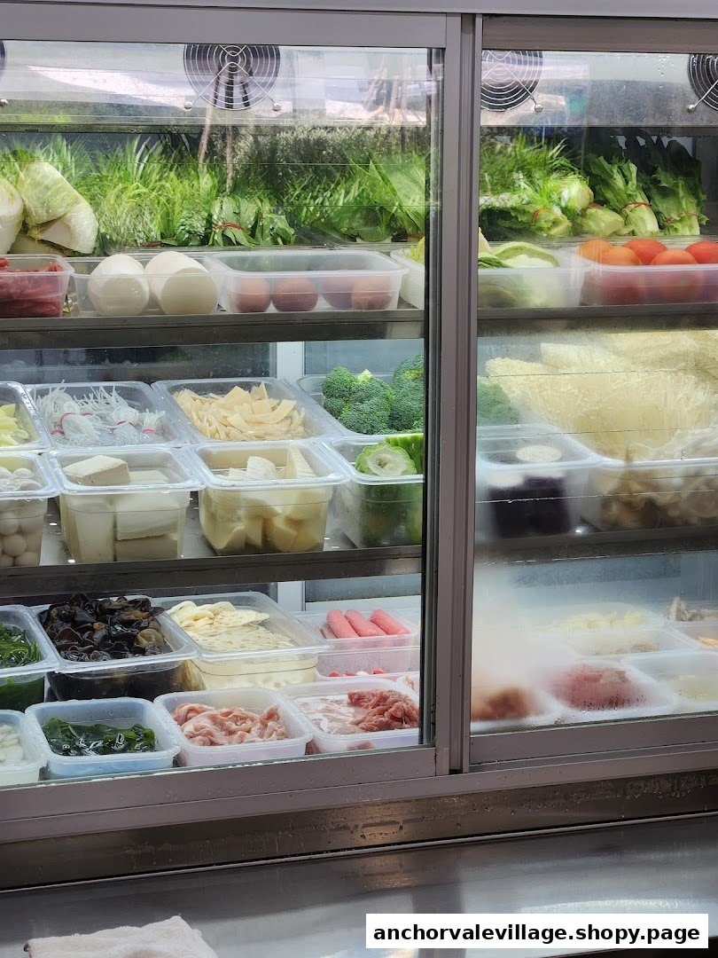 A refrigerated display case showcasing a wide variety of fresh ingredients for hotpot or grilled fish.