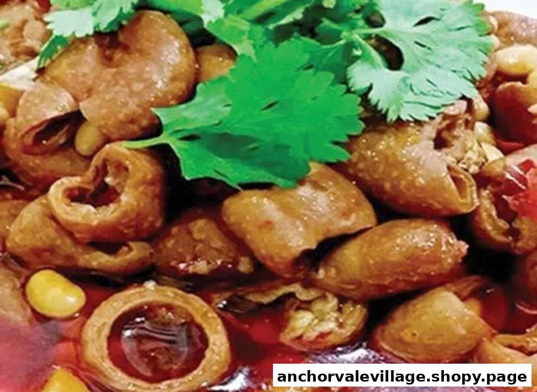 A close-up of a savory braised dish, possibly intestines, with cilantro in a rich red sauce.