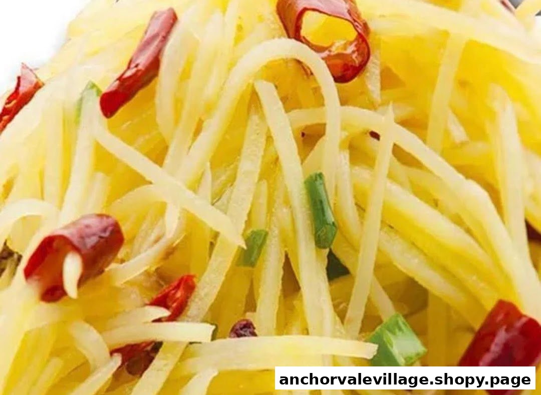 Close-up of shredded potatoes with red chilies and green onions, a classic spicy side dish.