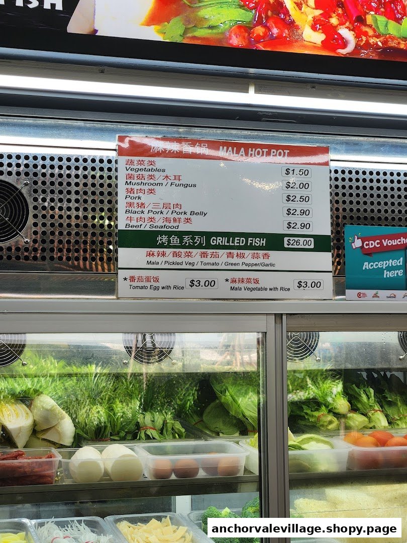 A menu board displaying Mala Hot Pot and Grilled Fish options with prices, alongside fresh ingredients.