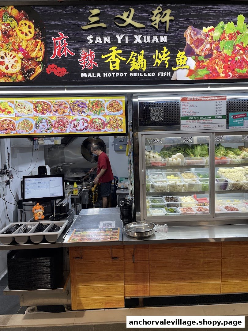 A bustling hotpot and grilled fish stall showcasing fresh ingredients and a chef at work.