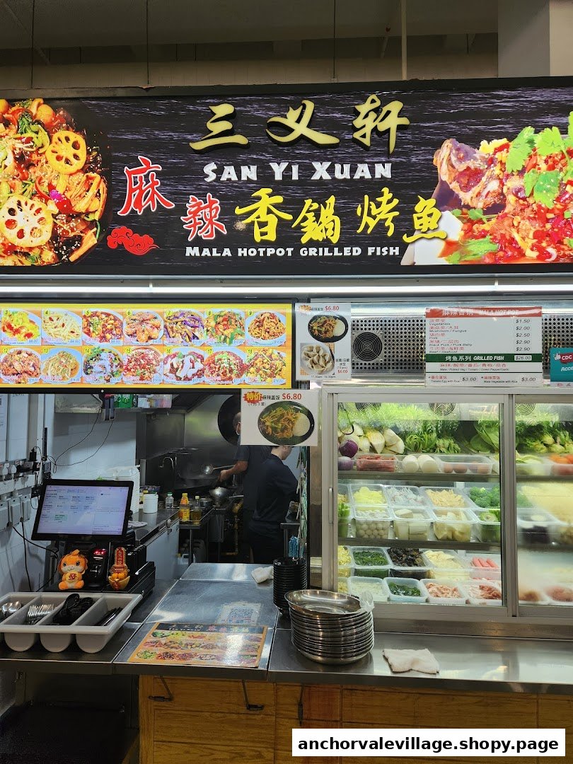 A vibrant interior shot of San Yi Xuan Mala Hotpot Grilled Fish, showcasing the counter, kitchen, and fresh ingredients.