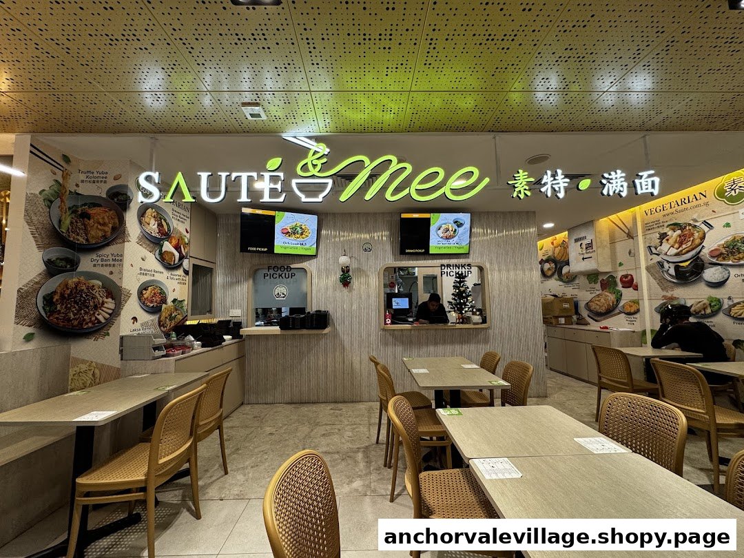 Interior view of Saute Mee, featuring a bright counter, dining tables, and wall graphics showcasing vegetarian dishes.