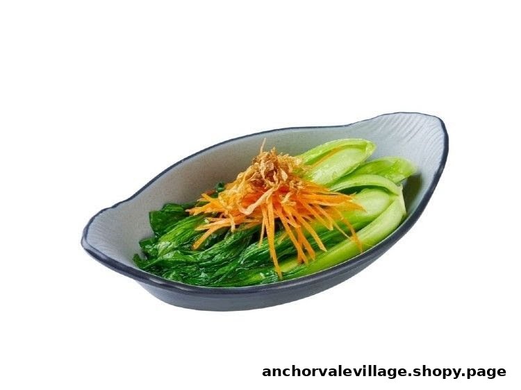 A bowl of vibrant green vegetables topped with shredded carrots and crispy fried shallots.