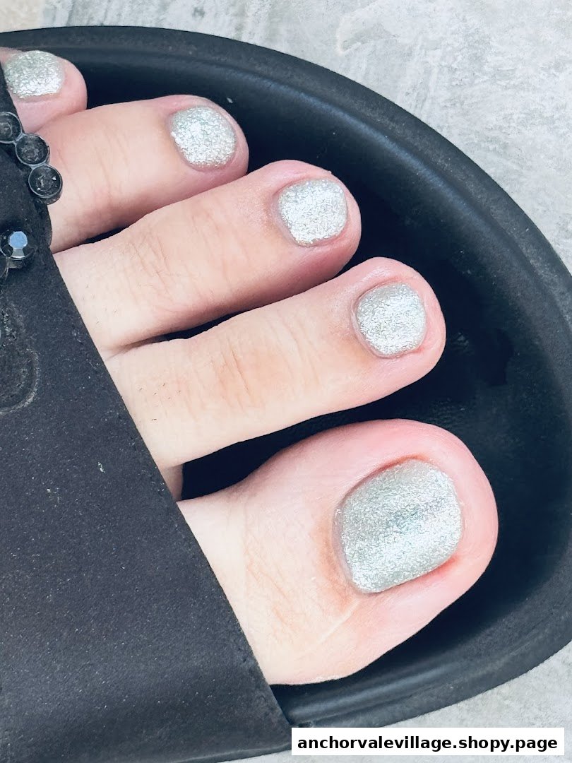 Close-up of a foot with glittery silver toenail polish, showcasing a pedicure.