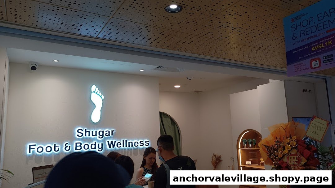 The bright shop front of Shugar Foot & Body Wellness with its illuminated logo and customers.