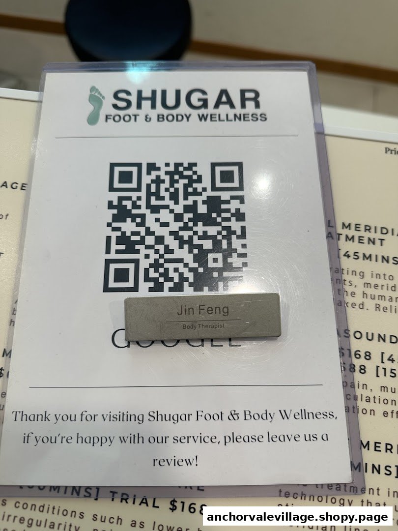 A sign for Shugar Foot & Body Wellness displaying a QR code for reviews and therapist information.