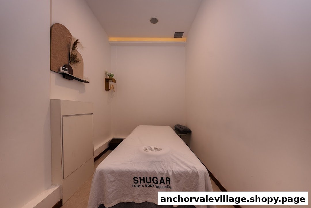 A clean, minimalist treatment room with a massage bed at Shugar Foot & Body Wellness.