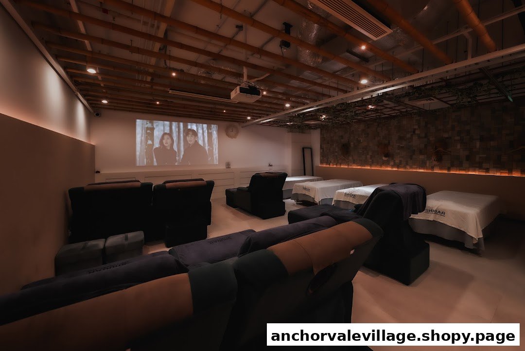 A cozy wellness room featuring recliners, massage beds, and a movie projected for ultimate relaxation.