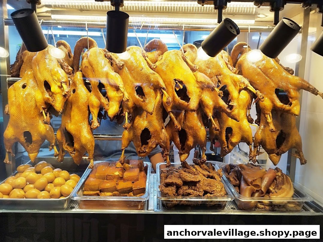 A display of roasted ducks and various braised dishes in a glass counter.