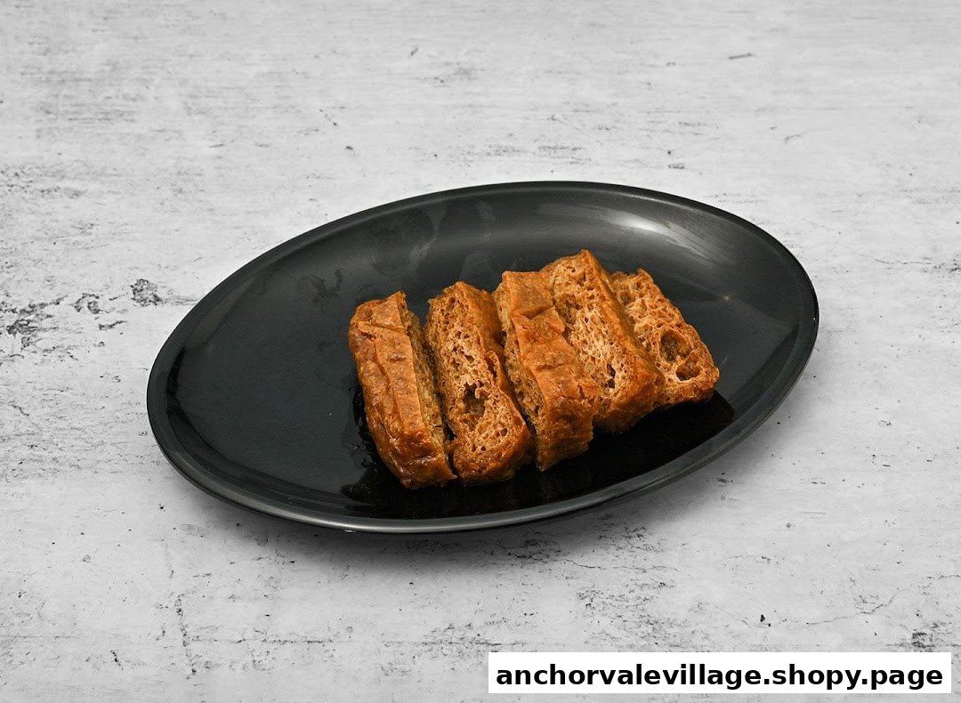 A black plate holds several slices of golden-brown fried tofu or similar savory item.