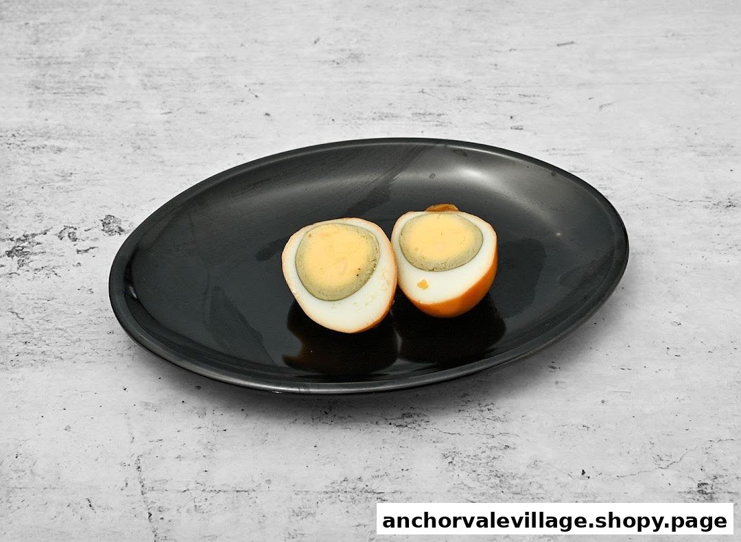 A black plate holds two halves of a perfectly braised egg, a common side dish.