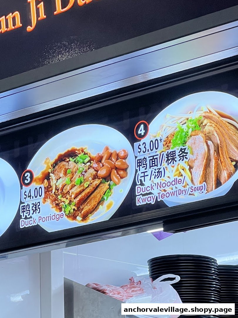 A vibrant menu board displaying Duck Porridge and Duck Noodle/Kway Teow dishes with prices.