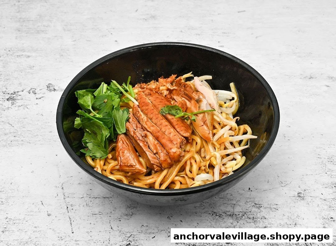A close-up of a delicious bowl of duck noodles with bean sprouts and fresh greens.
