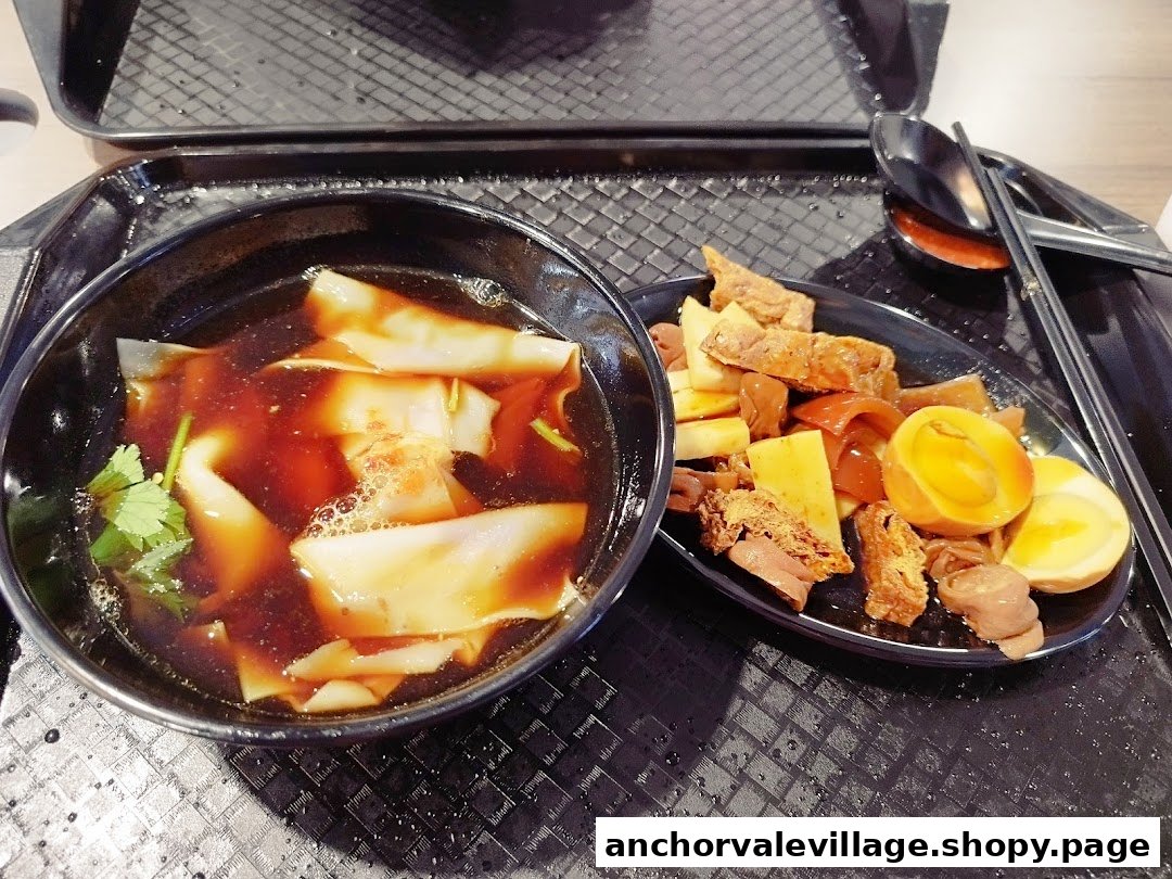 A delicious meal of kway chap noodles and assorted braised ingredients served on a black tray.