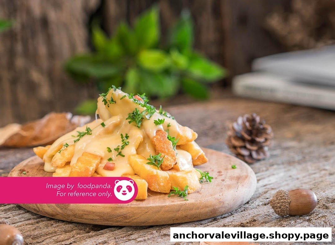 A close-up of golden fries generously topped with creamy cheese sauce and fresh parsley on a wooden board.