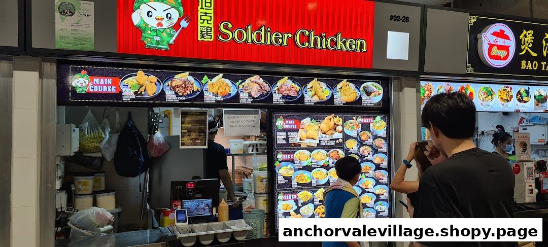 A vibrant food stall front displaying a variety of chicken and Western dishes on illuminated menu boards.