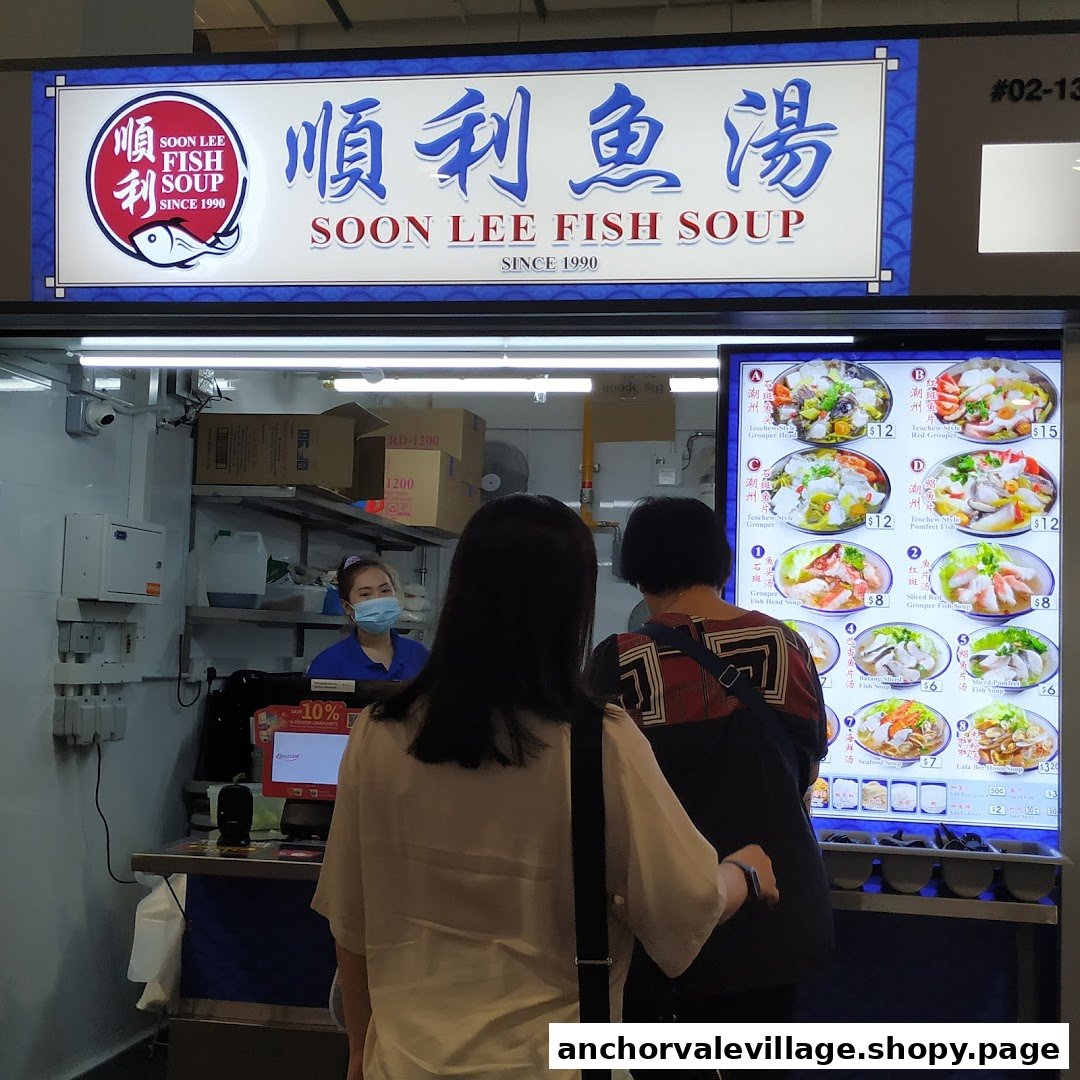 Customers queue at Soon Lee Fish Soup stall, featuring its prominent signage and digital menu board.