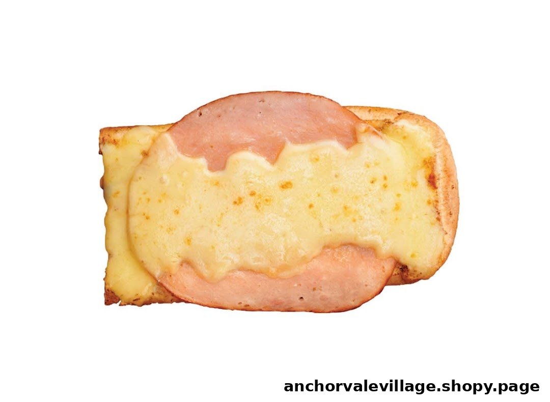 A close-up of a toasted sandwich or flatbread topped with melted cheese and ham slices.