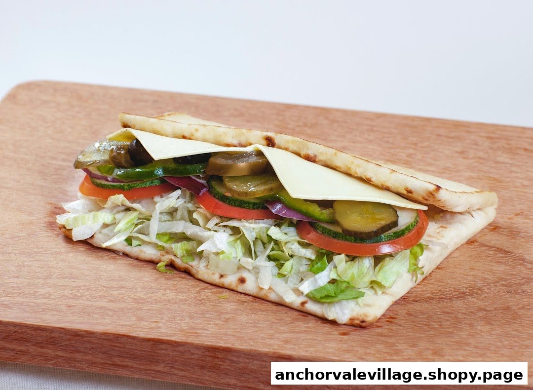 A fresh Subway flatbread sandwich filled with crisp vegetables and cheese on a wooden board.