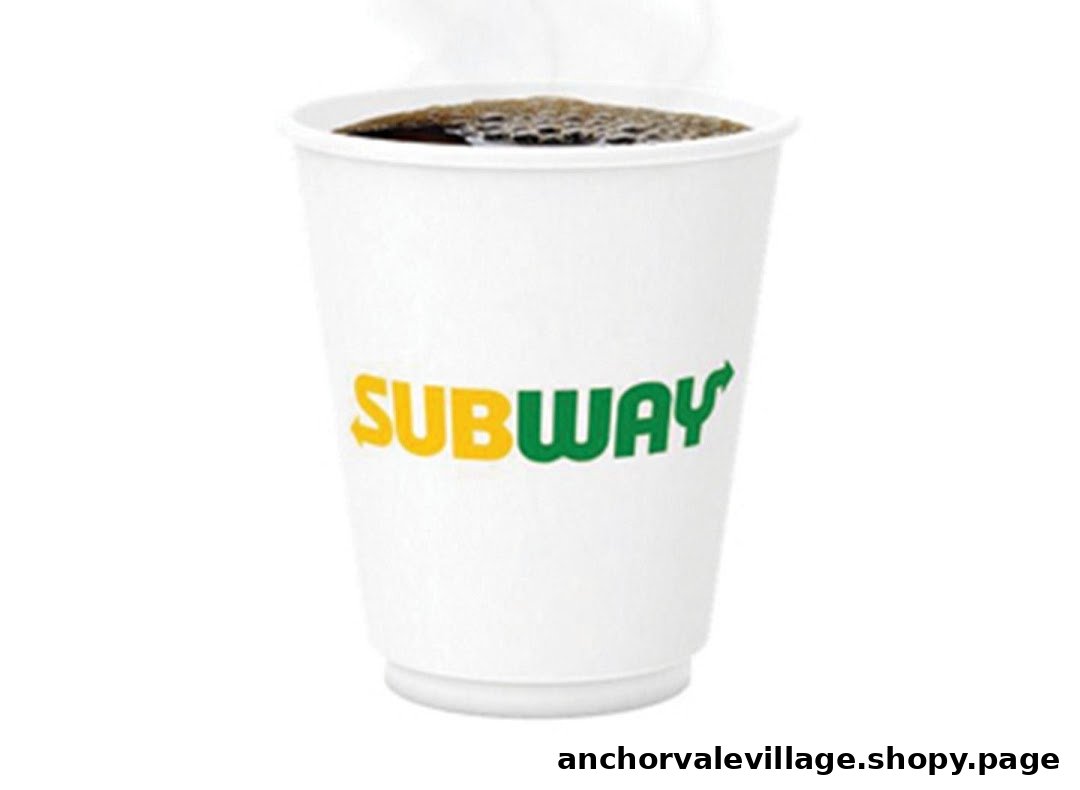 A white paper cup with the Subway logo, filled with a dark beverage, likely coffee, emitting steam.