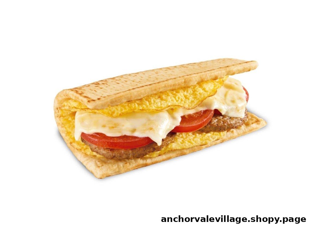 A delicious Subway breakfast sandwich featuring egg, melted cheese, sausage, and fresh tomato on toasted flatbread.